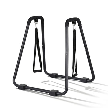 Black dip station parallel bars on white background with non-slip grip handles and dual hanging rings