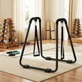 Person using dip station for inverted row exercise with training straps attached