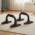 Two black push-up stands on cream rug in home gym setting, front-on view from ground level