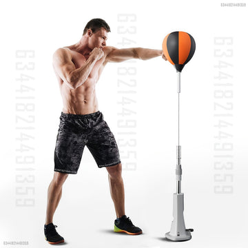 Man punching orange and black speed bag on adjustable silver stand with spring and weighted base