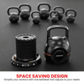 Powertrain adjustable kettlebell and weight plate stack on dark gym floor with seven traditional kettlebells blurred behind
