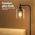 Close-up of arc floor lamp clear glass shade with glowing filament bulb, text overlay E27 60W max compatible