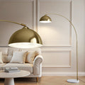 Gold arc floor lamp arching over a cream sofa in a paneled room, with dome shade interior close-up in foreground