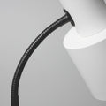 Close-up of black ribbed flexible gooseneck connecting to white cylindrical spotlight head on grey background