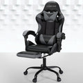 Artiss black and grey massage gaming chair with footrest extended in room with geometric wall panels