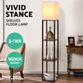 Artiss 3-tier walnut shelf floor lamp with lit white shade, 160cm height, shown with decor items and armchair in room setting