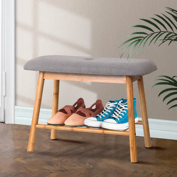Bamboo shoe bench with grey button-tufted cushion and slatted bottom shelf in hallway setting