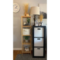 Bamboo slim shelving unit in bedroom styled with plants, white cushion and books beside a wall clock and table lamp