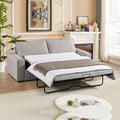 Light beige fabric sofa bed extended in living room with fireplace, plant and brown throw blanket on white mattress