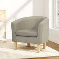 Beige fabric tub armchair with natural wood legs in minimal room corner with art and window light