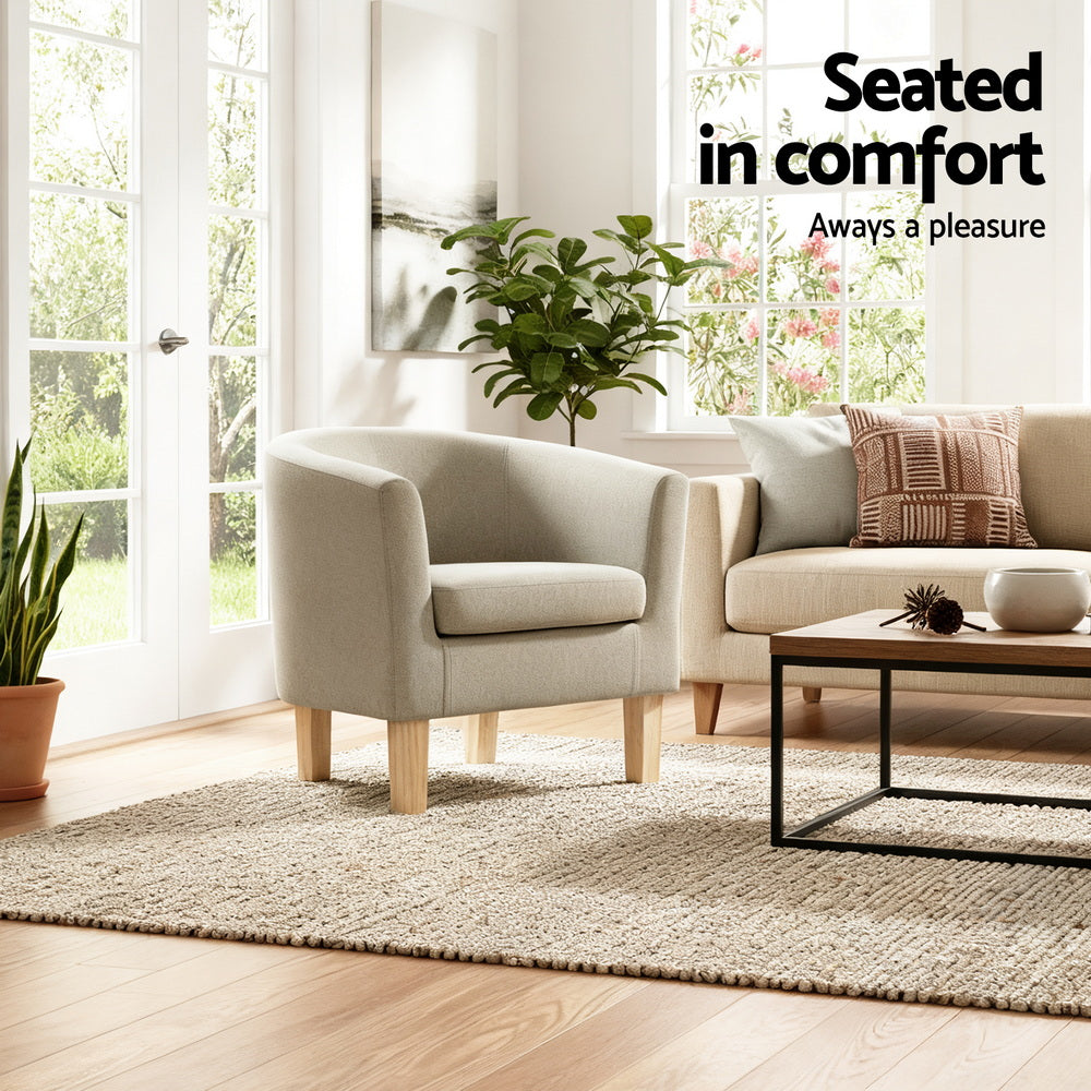 Beige fabric tub armchair in sunny living room with sofa and plants showing Seated in comfort text overlay