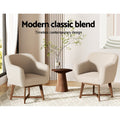 Beige linen barrel armchair with rounded shell shape and walnut cross-brace legs, front view on white background
