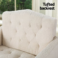 Close-up of cream teddy armchair diamond-tufted backrest with Tufted backrest text and window with trees behind