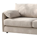 Close-up of beige plush sofa left armrest and seat cushion showing soft textured fabric