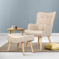 Beige fabric button-tufted wingback armchair with footstool ottoman in lifestyle room with blue wall and striped rug