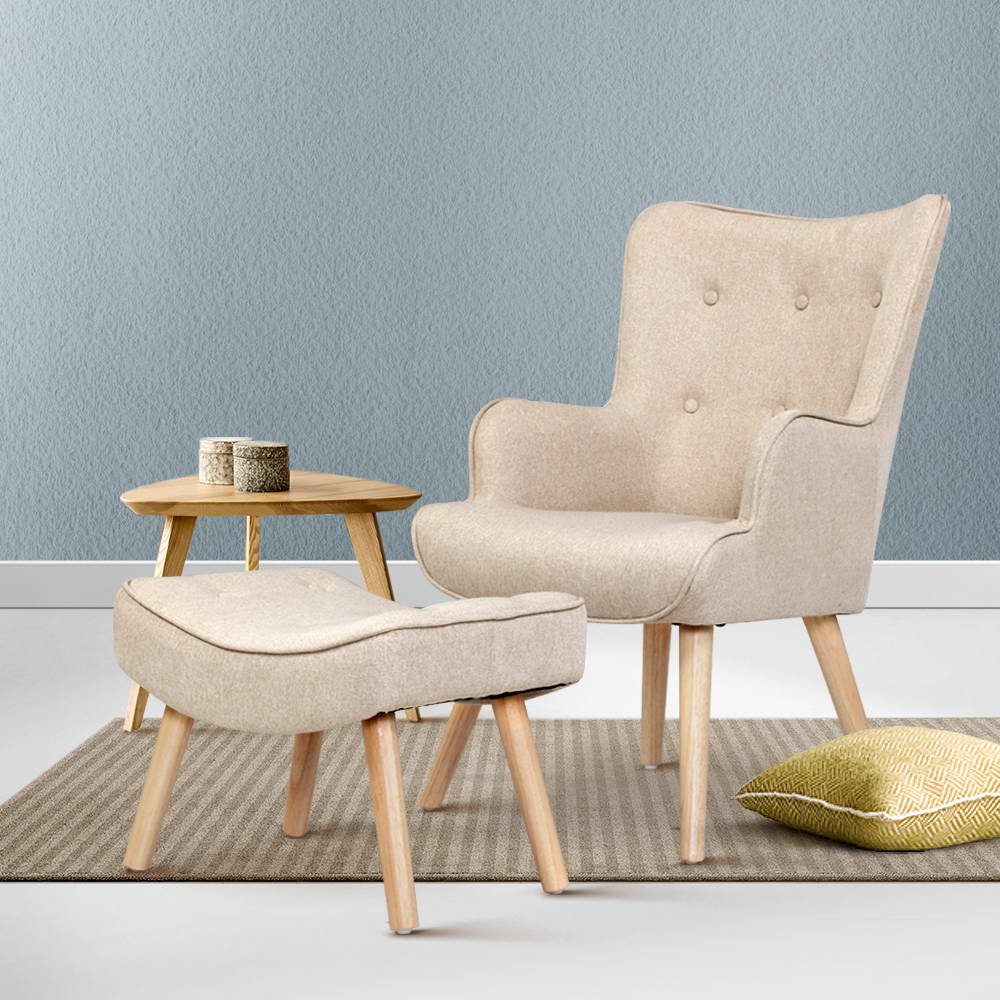 Beige fabric button-tufted wingback armchair with footstool ottoman in lifestyle room with blue wall and striped rug