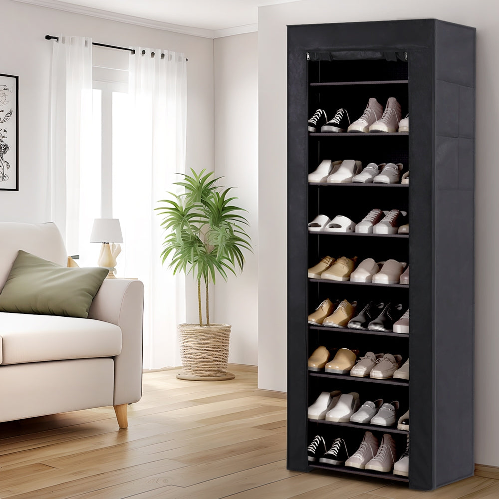 Black fabric-covered 10-tier shoe rack in living room with front cover open showing shoes on shelves