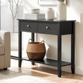 Black console table with two drawers and lower shelf in living room, styled with white vases and wicker basket