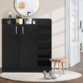 Black shoe cabinet with 2 doors and 5 open side shelves in hallway, white C-handles, decor on top