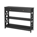 Black console table with one drawer, X-cross panels, two lower shelves and built-in power outlet, angle view on white