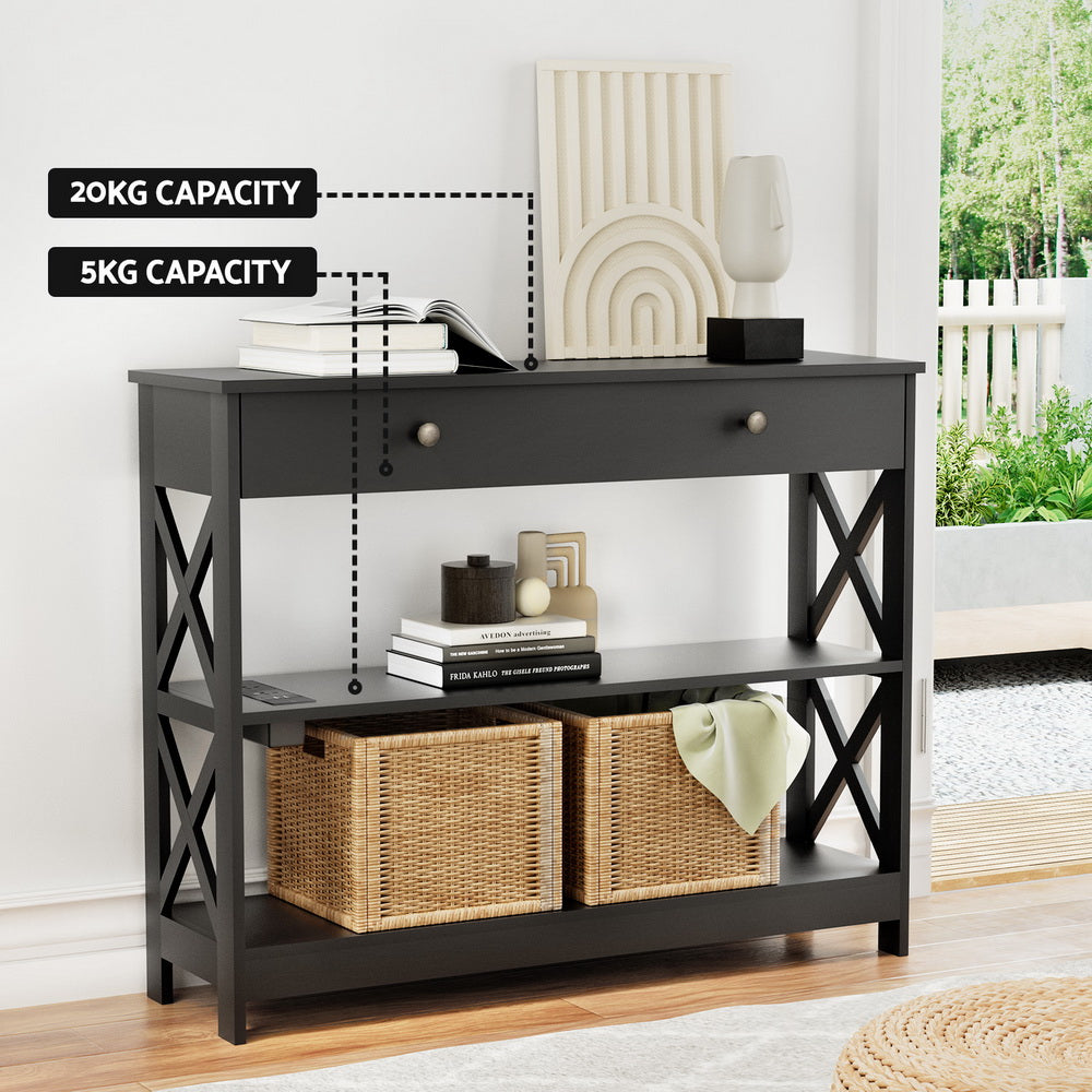 Black 3-tier console table in room, badges: top 20KG capacity, drawer 5KG capacity, wicker baskets on lower shelf