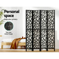 Black 4-panel criss-cross geometric room divider in bedroom lifestyle with personal space and two-way metal hinges callout