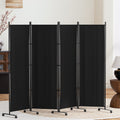 Black 4-panel fabric room divider on wheels in living room lifestyle with blossoming branch lamp and round wood pedestal