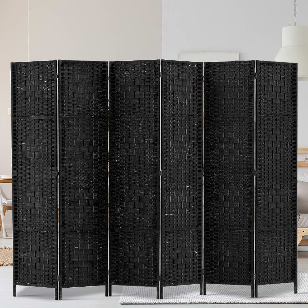 Black 6-panel woven paper rope room divider in lifestyle bedroom against white wall with pendant lamp and wood floor
