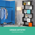 Black S-shaped bookcase in room with blue room divider and clothes rack, text reads Unique Artistry