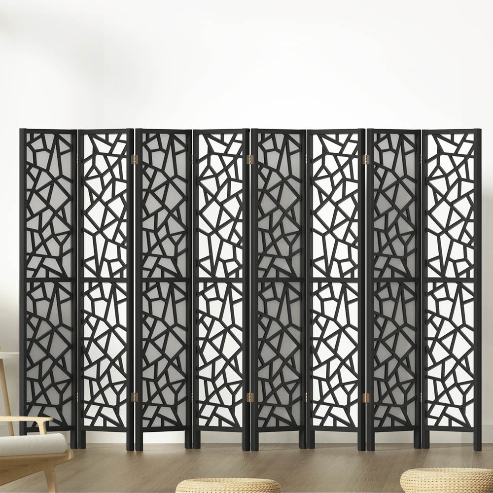 Black 8-panel MDF room divider with geometric star pattern cutouts in lifestyle room with chair and ottomans