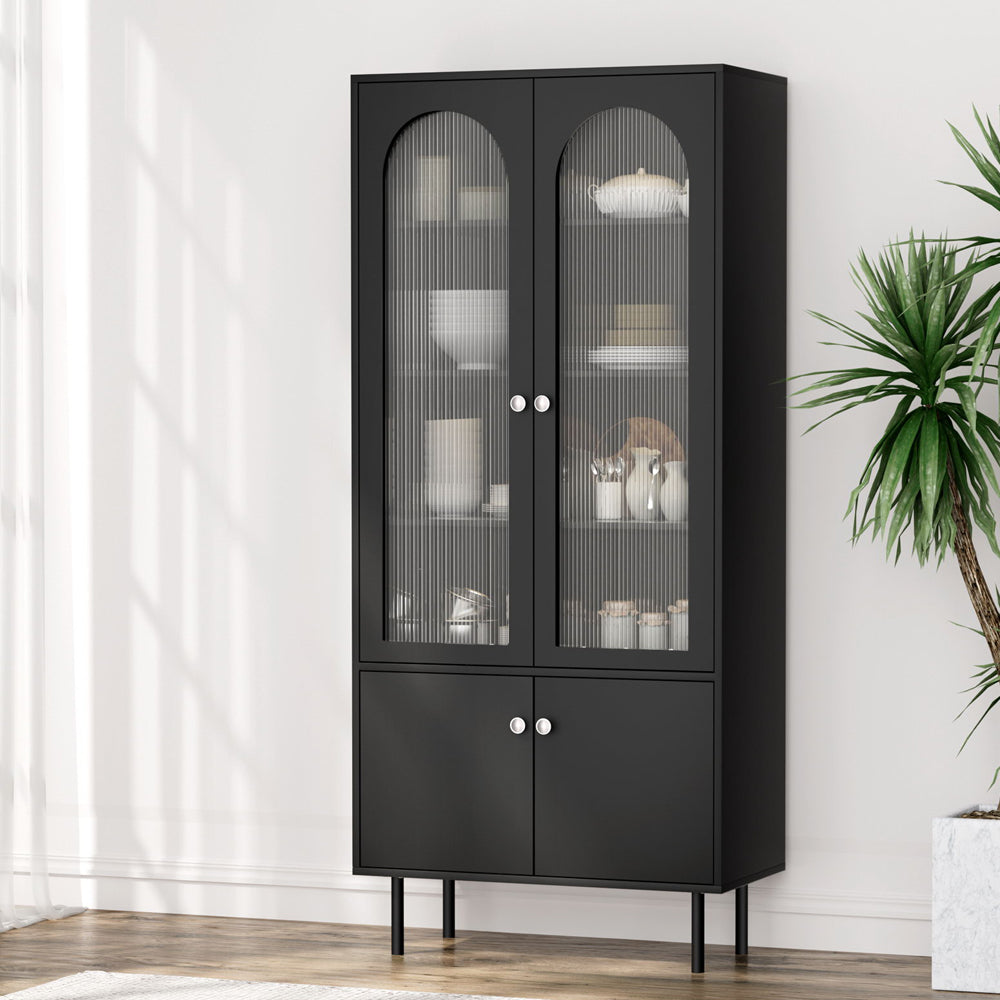 Tall black cabinet with two arched fluted glass upper doors and two solid lower doors, dinnerware visible inside, metal legs