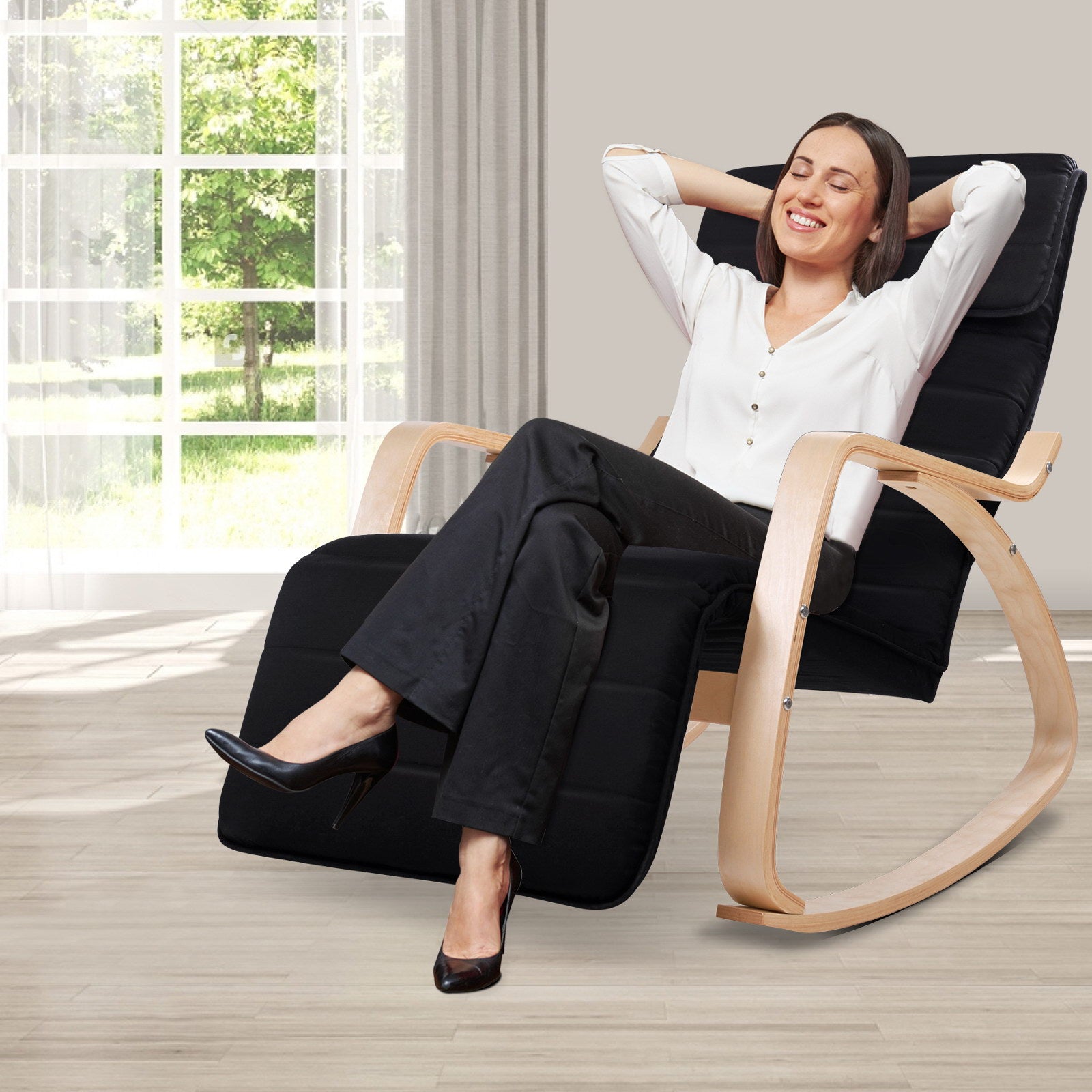 Woman reclining in black bentwood rocking recliner with hands behind head, lifestyle room with large window and curtains