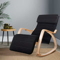 Black ribbed fabric bentwood rocking recliner with extended footrest, lifestyle room with palm plant and wooden side table