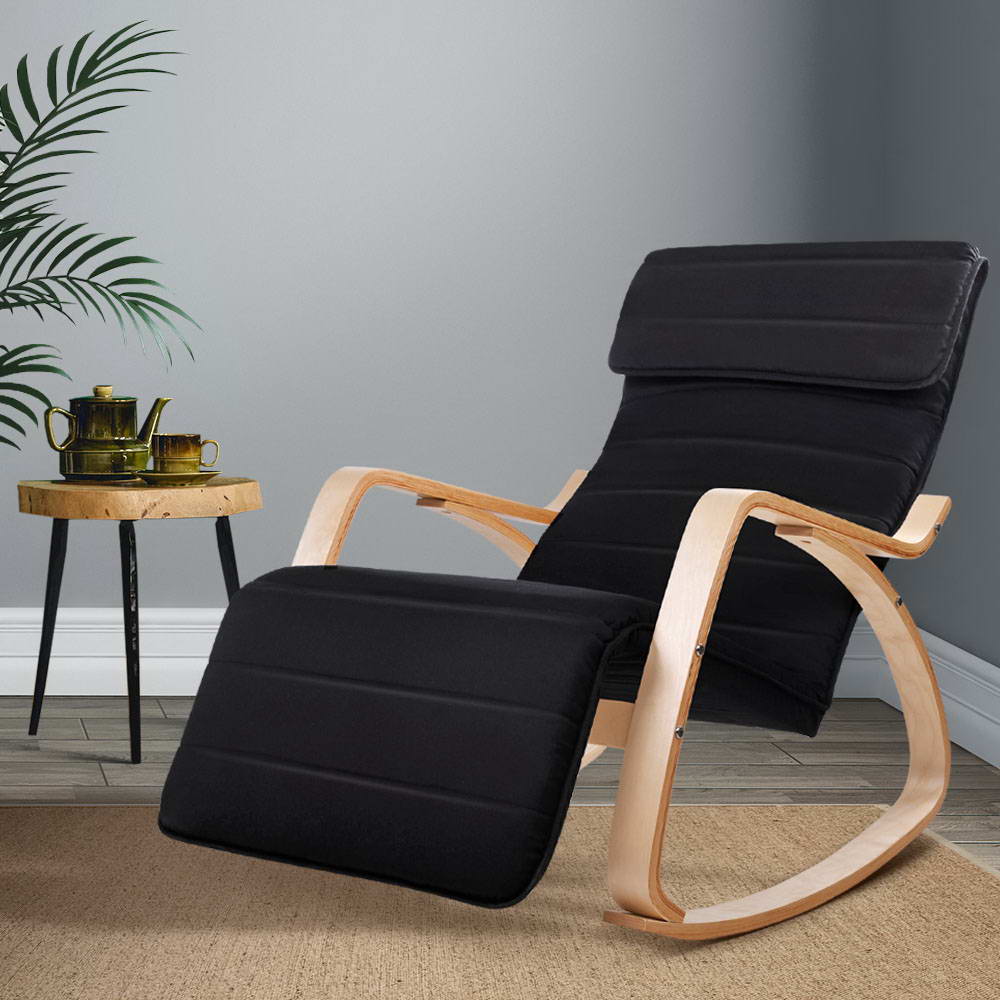 Black ribbed fabric bentwood rocking recliner with extended footrest, lifestyle room with palm plant and wooden side table