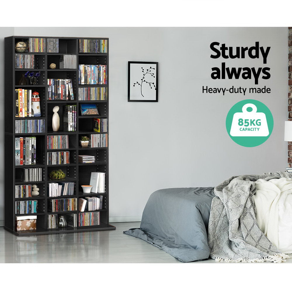 Tall black CD and DVD media unit in bedroom filled with CDs, text: Sturdy always, Heavy-duty made, 85kg capacity