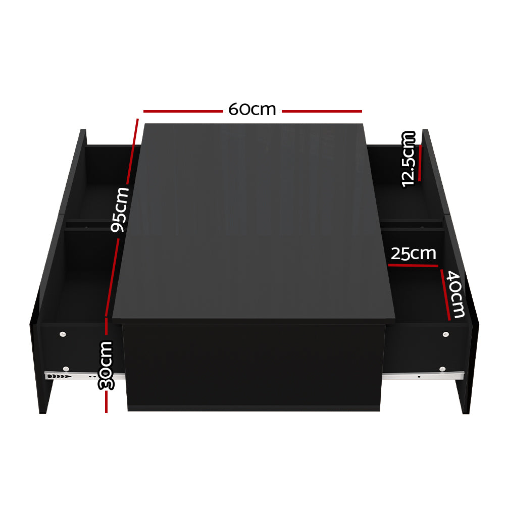 Black high-gloss rectangular coffee table with four drawers and textured panel front, styled with a plant and books in a