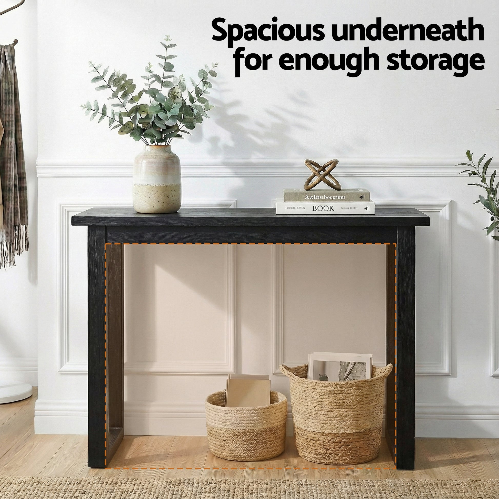 Black console table in hallway with open lower space and wicker baskets, text "Spacious underneath for enough storage"