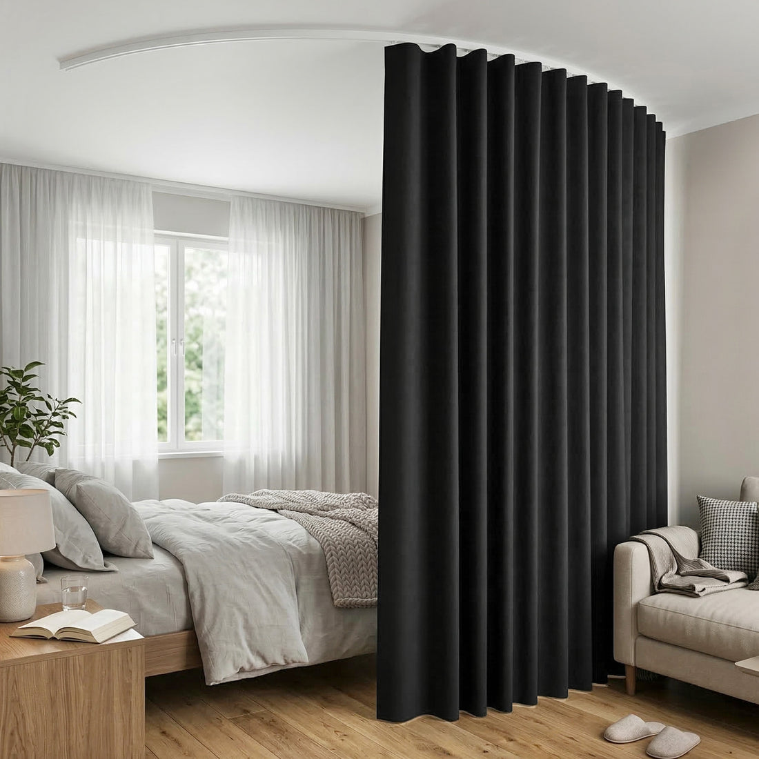 Black room divider curtain on white curved ceiling track in bedroom with grey bed sheer curtains plant and beige sofa