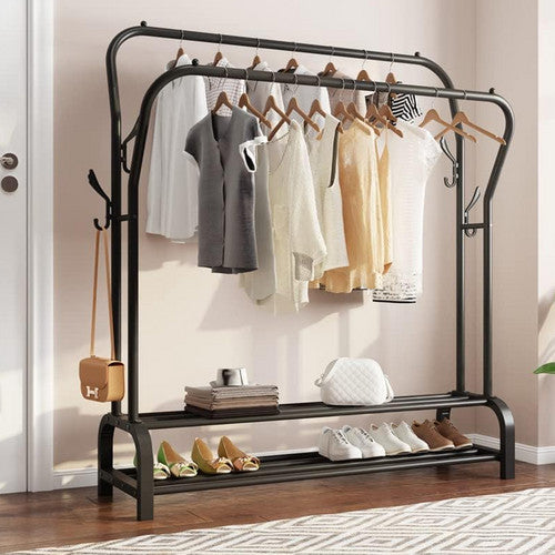 Black double-rail garment rack in bedroom entry loaded with neutral earth-tone clothes shoes and accessories on shelf