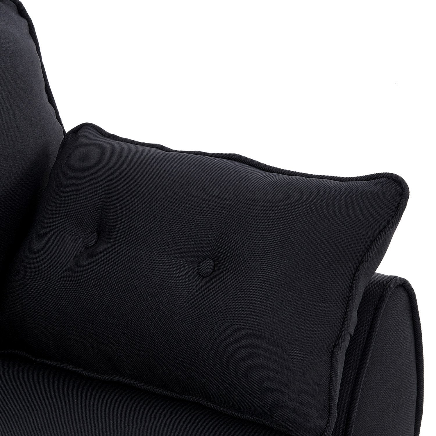 Close-up of black button-tufted rectangular scatter pillow resting on rounded sofa arm
