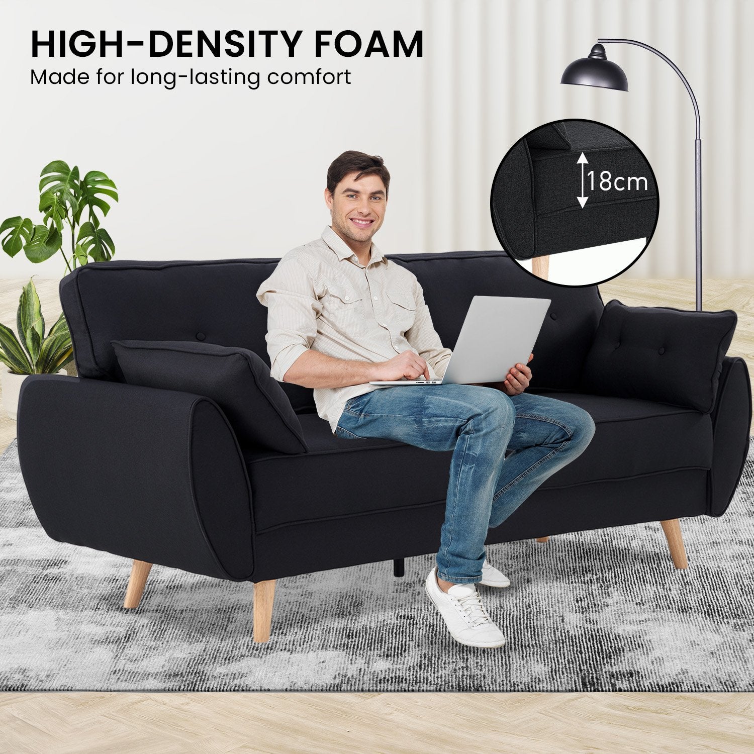 High-density foam infographic showing man seated on black fabric sofa bed in room with 18cm foam depth callout