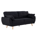 Black fabric sofa with rounded arms, button-tufted back cushions and natural wood legs, angle view