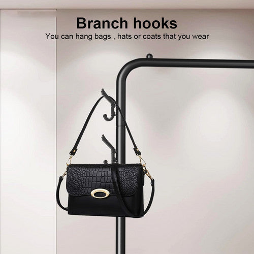 Black steel garment rack with bottom shelf loaded with hanging clothes bags shoes and basket in living room
