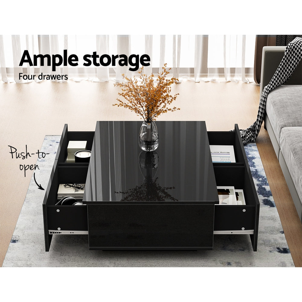Black gloss coffee table with four push-to-open drawers all open showing storage in living room