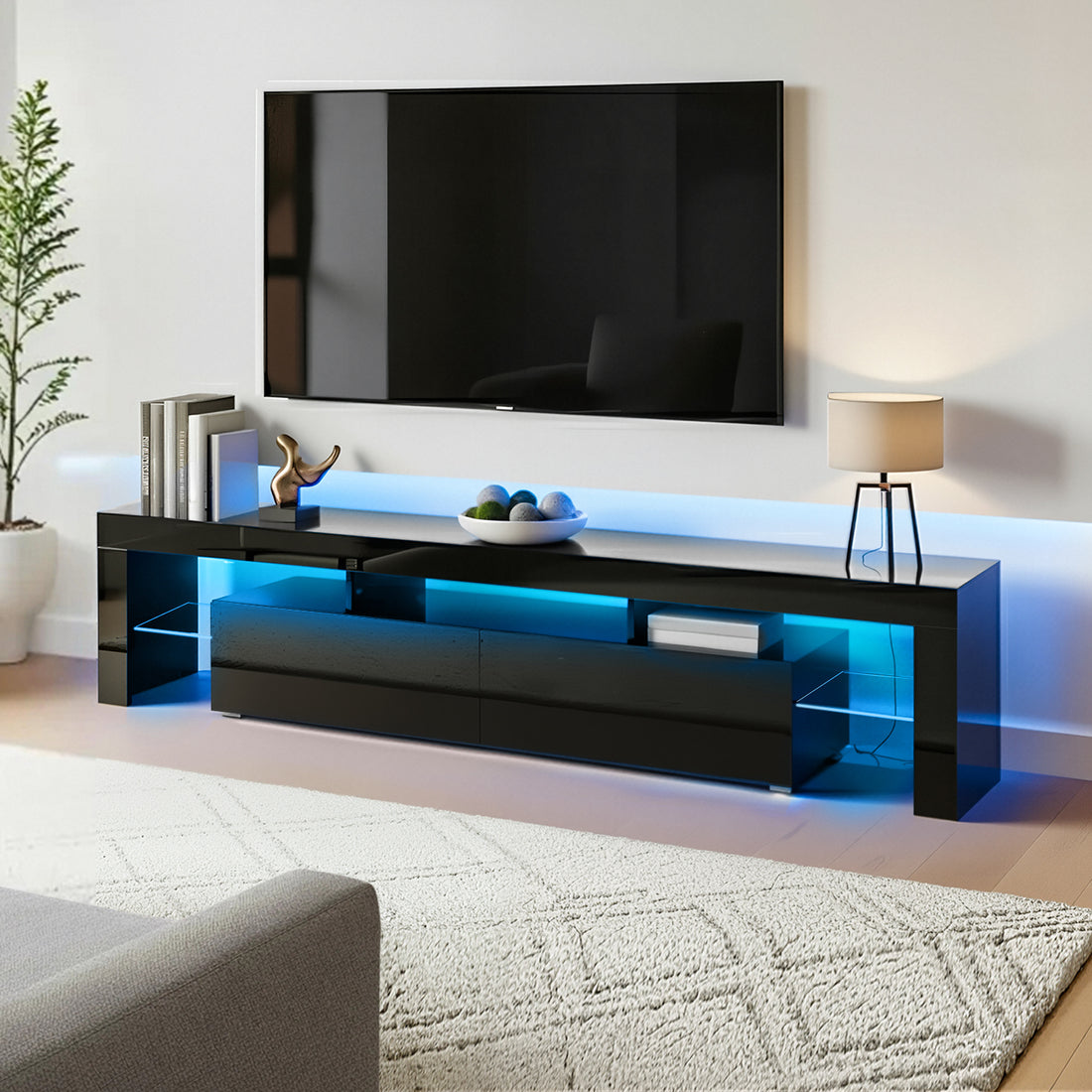 Black glossy LED TV unit 200cm lifestyle in large room with blue LED strip decorative lamp and items