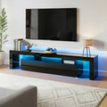 Black glossy LED TV unit 200cm lifestyle in large room with blue LED strip decorative lamp and items