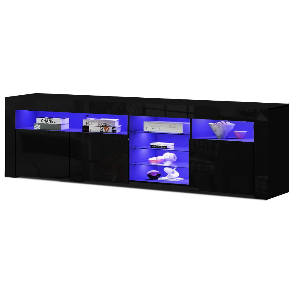 Black glossy LED TV unit 180cm angle view with blue LED lit shelves showing books and ornaments on white background