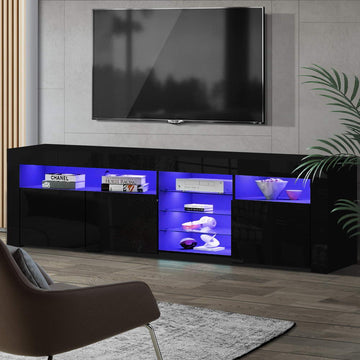 Black glossy LED TV unit 180cm in living room with blue LED illuminating shelves holding books and headphones