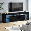 Black glossy LED TV unit in grey room with wall TV blue LED strip palm plant AV receiver and WM letter sculptures