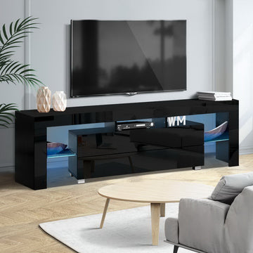 Black glossy LED TV unit in grey room with wall TV blue LED strip palm plant AV receiver and WM letter sculptures